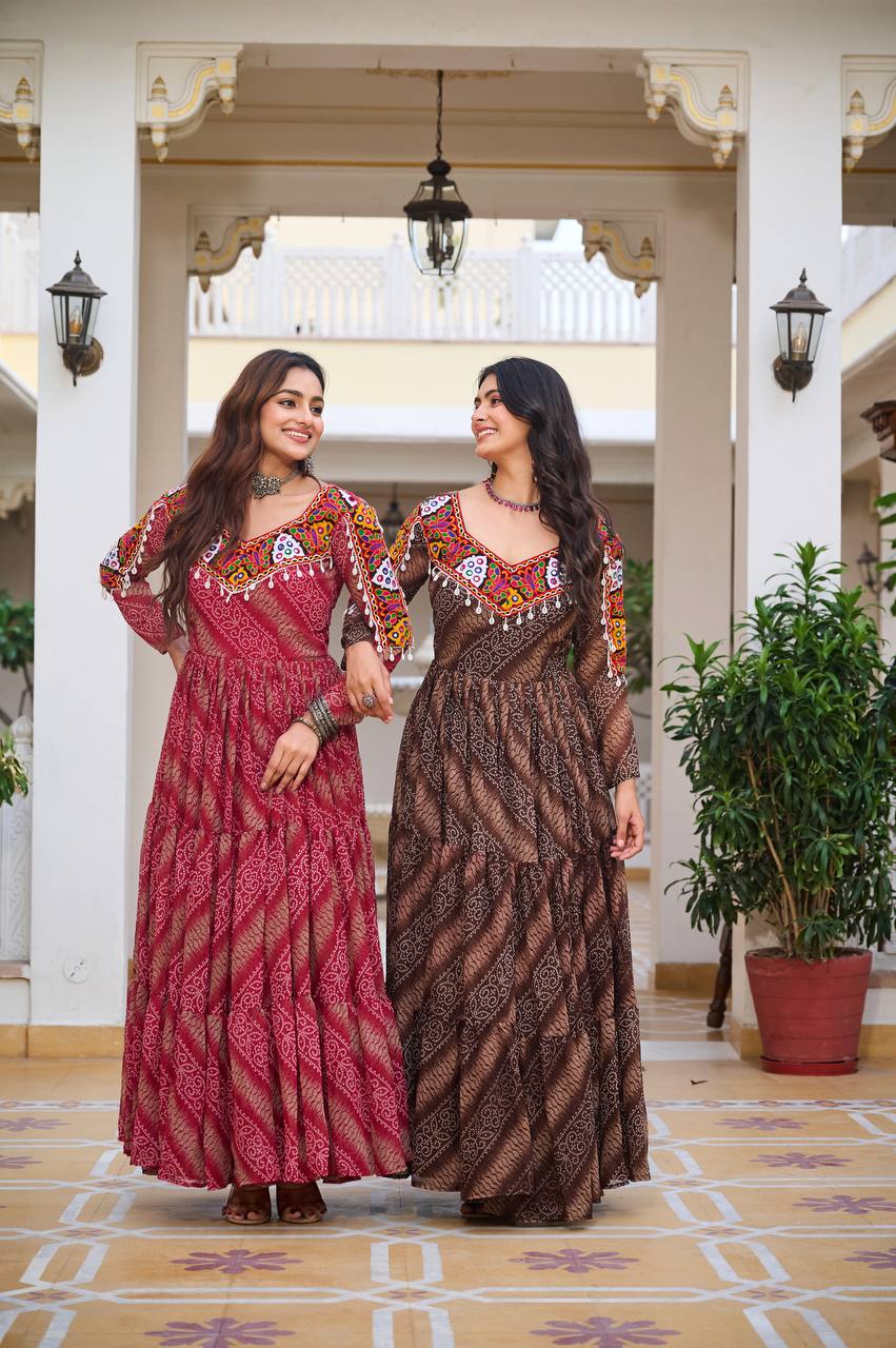 Women in red and brown Gamathi gowns, walking arm in arm, ready for festive Navratri events.