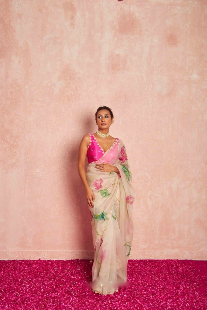 Model wearing elegant pink organza silk saree with floral design.