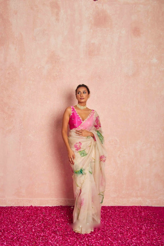 Model wearing elegant pink organza silk saree with floral design.