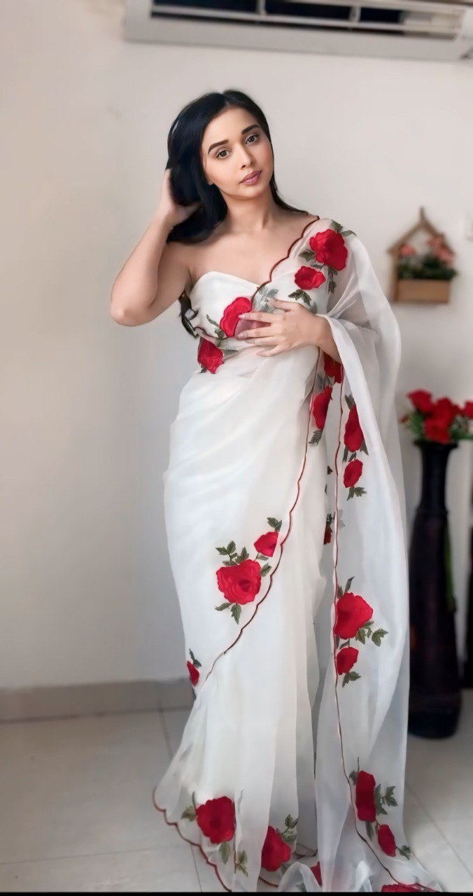 Close-up of the ready-to-wear white organza saree with red rose print.
