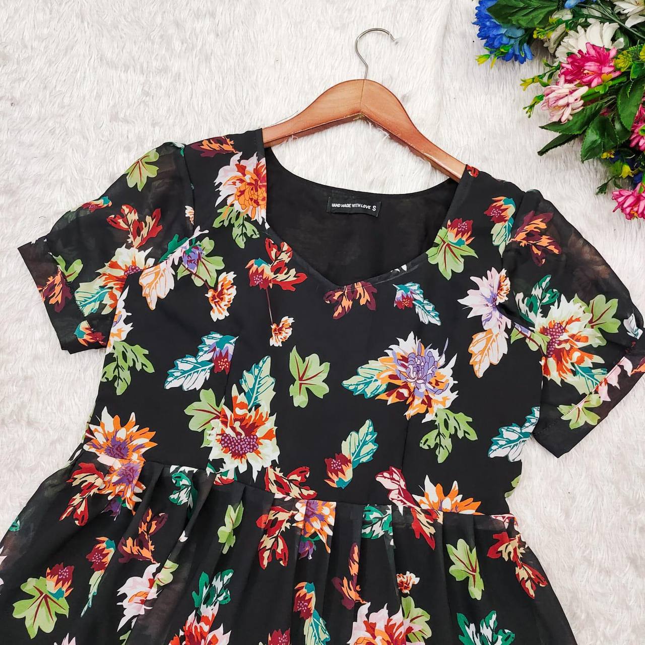 Close-up of the Floral Getaway black floral dress. Details of the neckline and floral pattern visible.