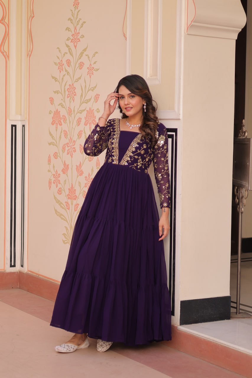Woman in purple gown with sheer sleeves and details