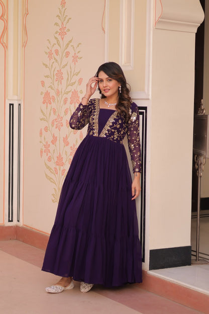 Woman in purple gown with sheer sleeves and details
