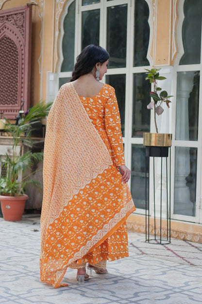 Woman in orange floral kurti set, holding soft dupatta, styled for comfort and everyday elegance.