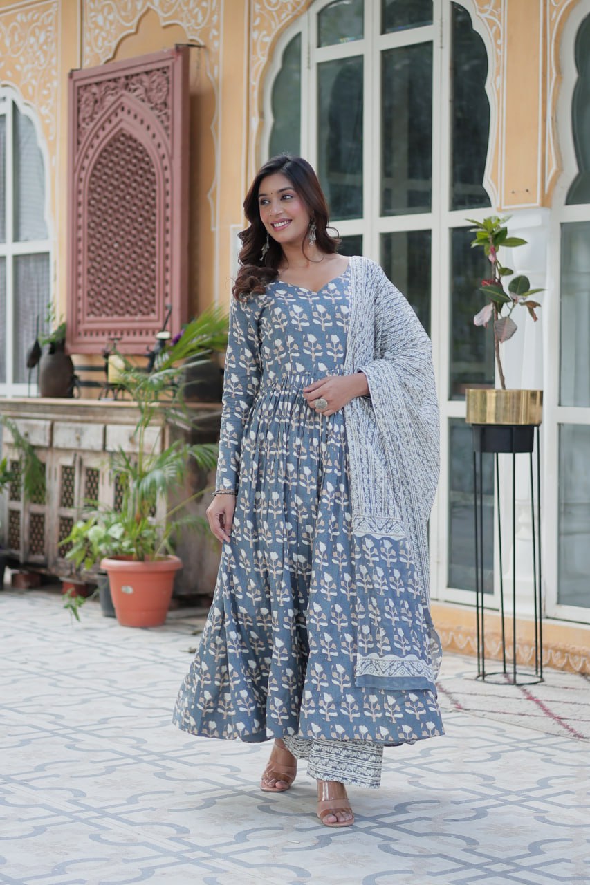 Woman stands in a blue floral kurti set with V-neck and flowy skirt, styled for versatile occasions.