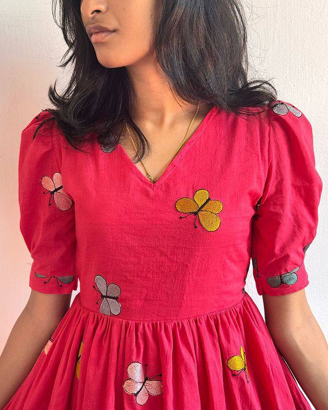 Close-up of the pink Butterfly Maxi Dress showing the V-neck and butterfly print details.