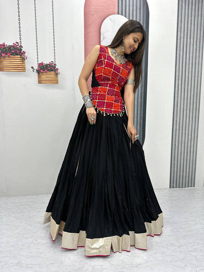 Model in swirling black lehenga and red foil print choli, showing off elegant festive Navratri attire.