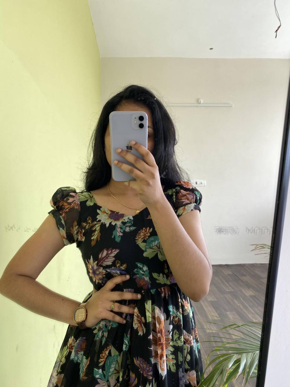 Model posing in a stylish black 'Floral Getaway' dress with faux georgette fabric and floral pattern.