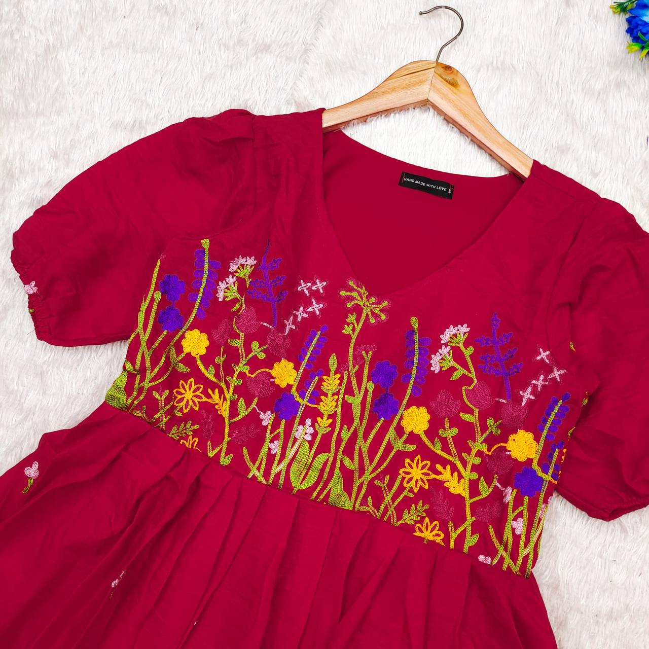 Close-up of red Floral Embrace dress by Rangbhoomi, showing exquisite chain stitch floral embroidery.