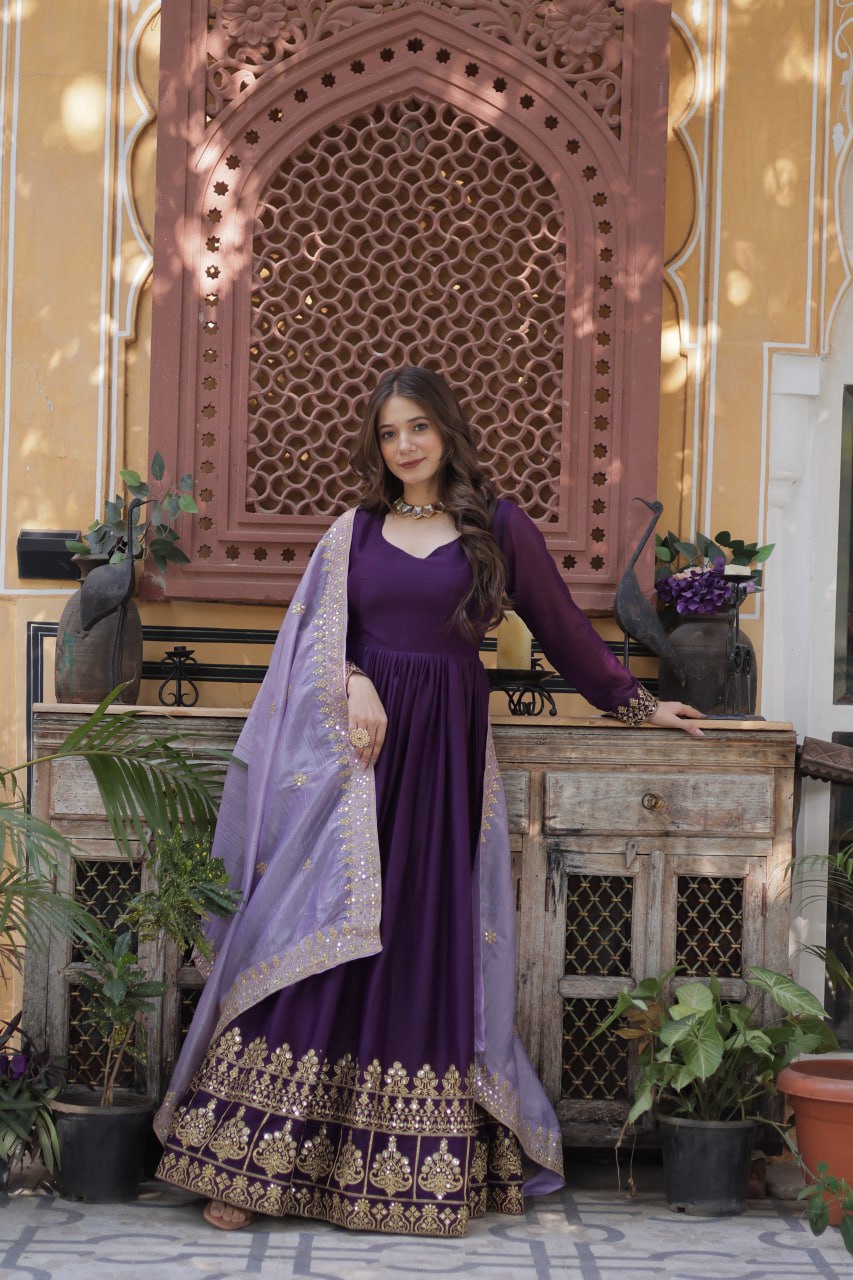 Designer purple gown with a gold embroidered hem and purple dupatta.