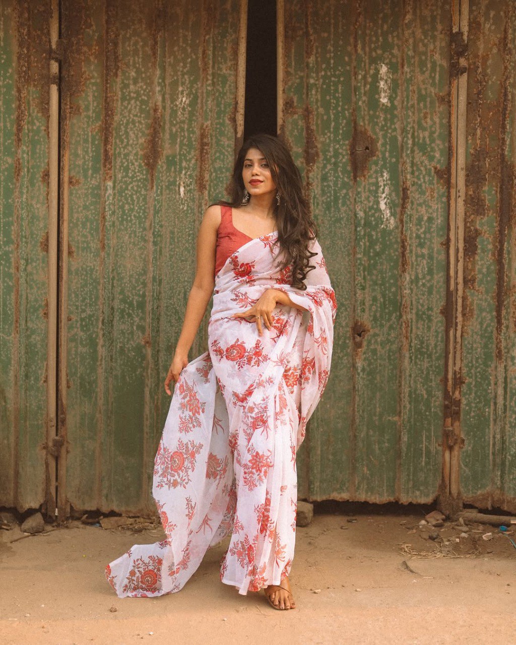 Off-white floral saree in georgette fabric, ready to wear, model wearing the saree.