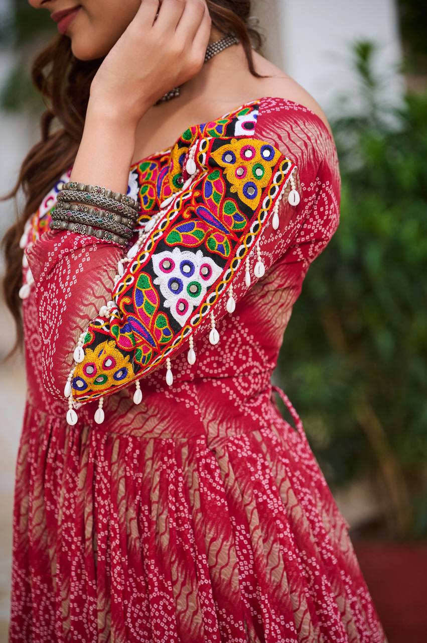 Close-up of colorful Gamathi embroidery and real mirror work on the sleeve of the red Bandhni gown.