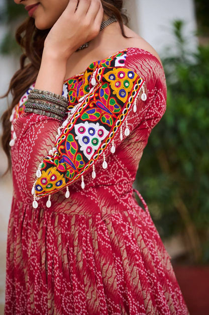 Close-up of colorful Gamathi embroidery and real mirror work on the sleeve of the red Bandhni gown.
