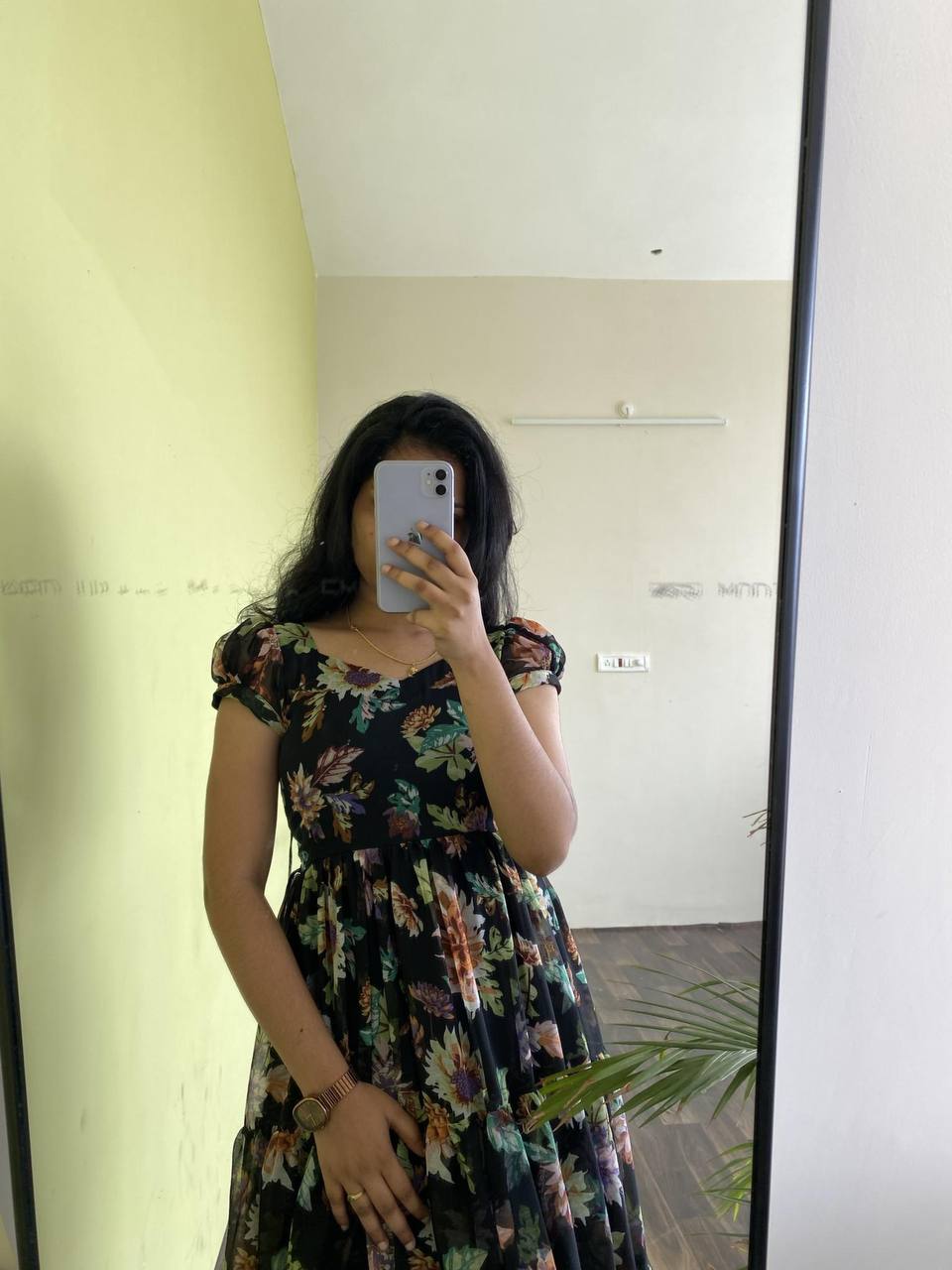 Close-up of the 'Floral Getaway' black dress with colorful floral print. Tiered design, short sleeves.