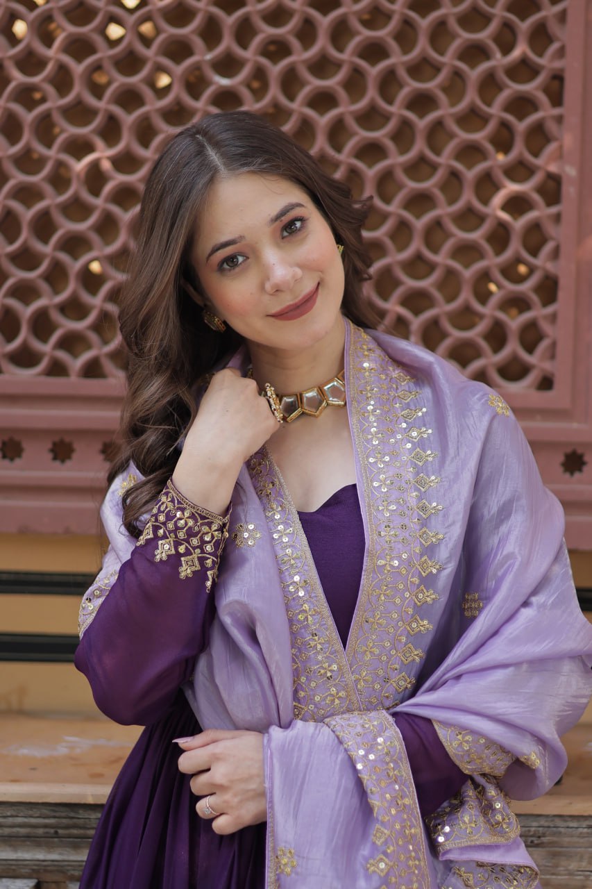 Close-up of gold embroidered details on a purple gown and dupatta.