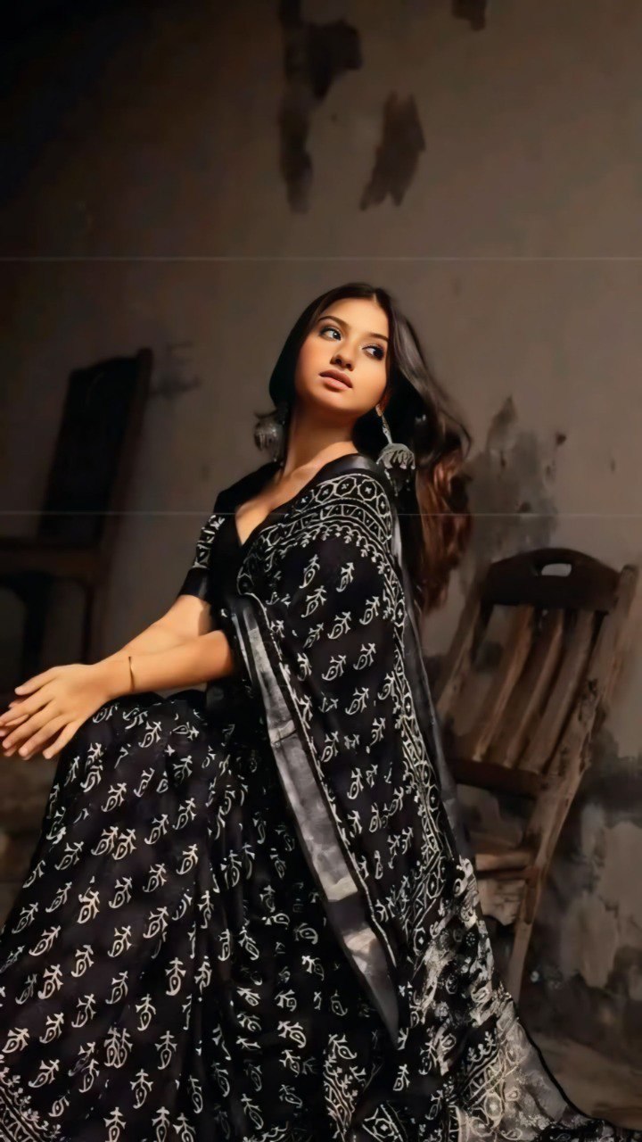 Model wearing a black and white cotton saree with a traditional print.