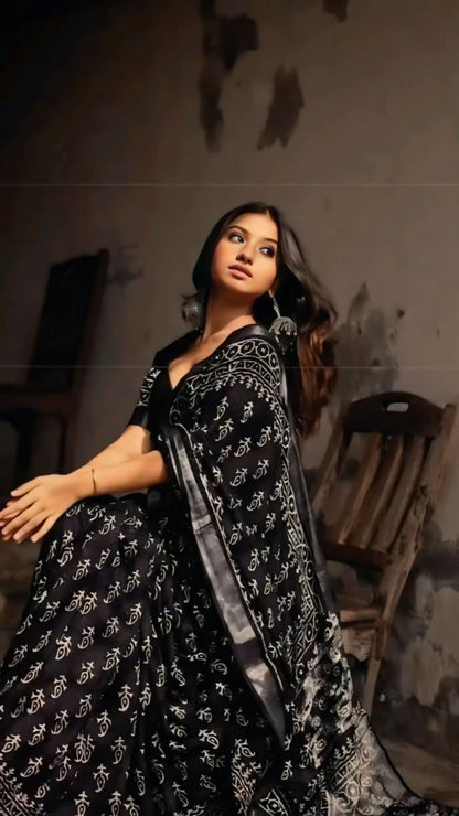 Model wearing a black and white cotton saree with a traditional print.