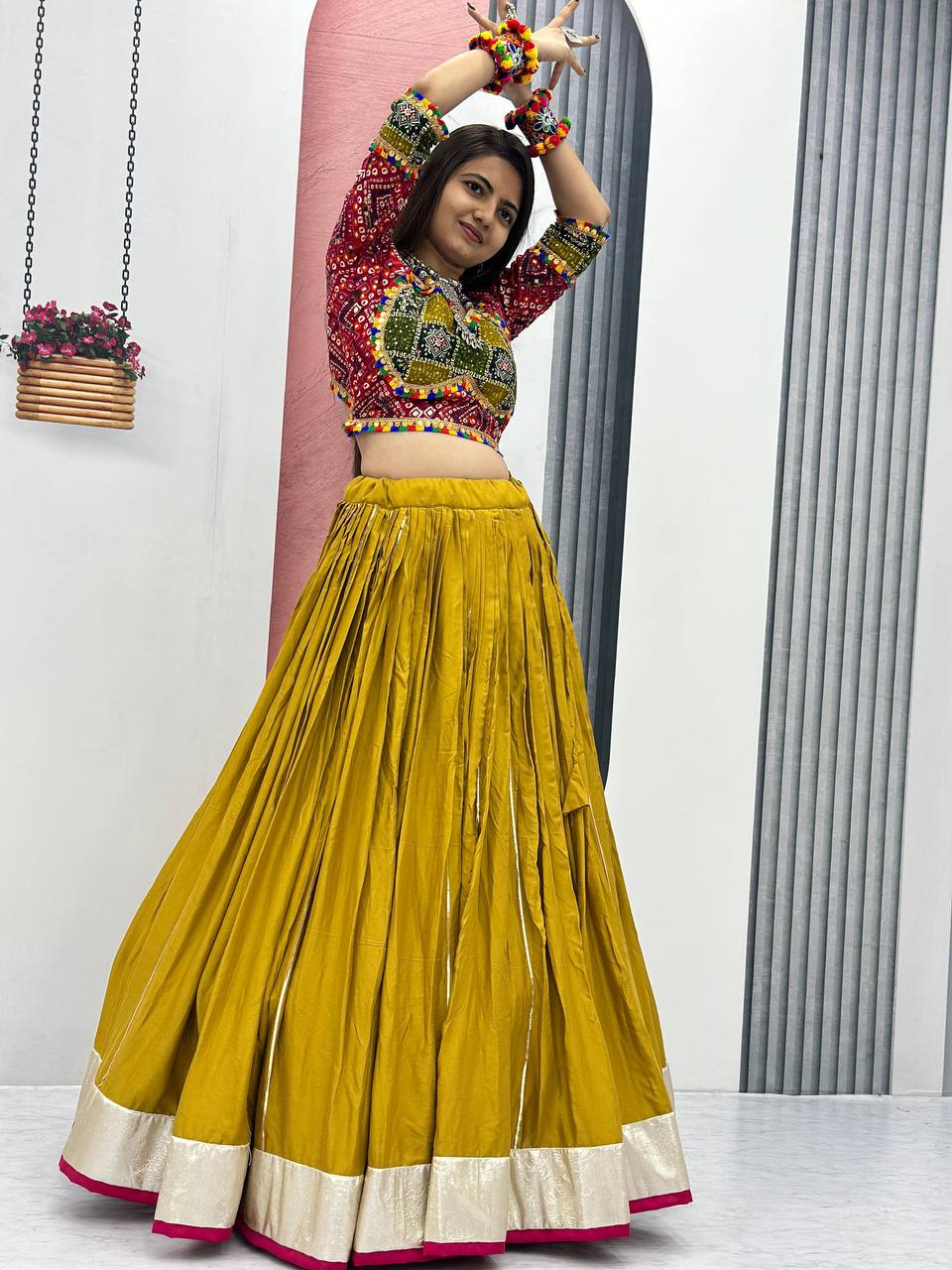 Golden Gamthi lehenga with vibrant red choli and six-meter flair, perfect for festive dances.