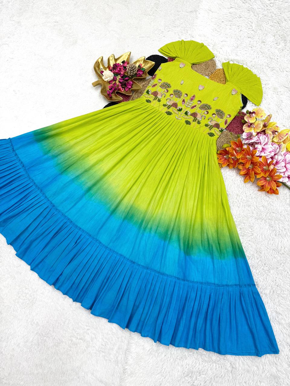 Overhead angle of the green and blue gown showing the full skirt and handworked details.