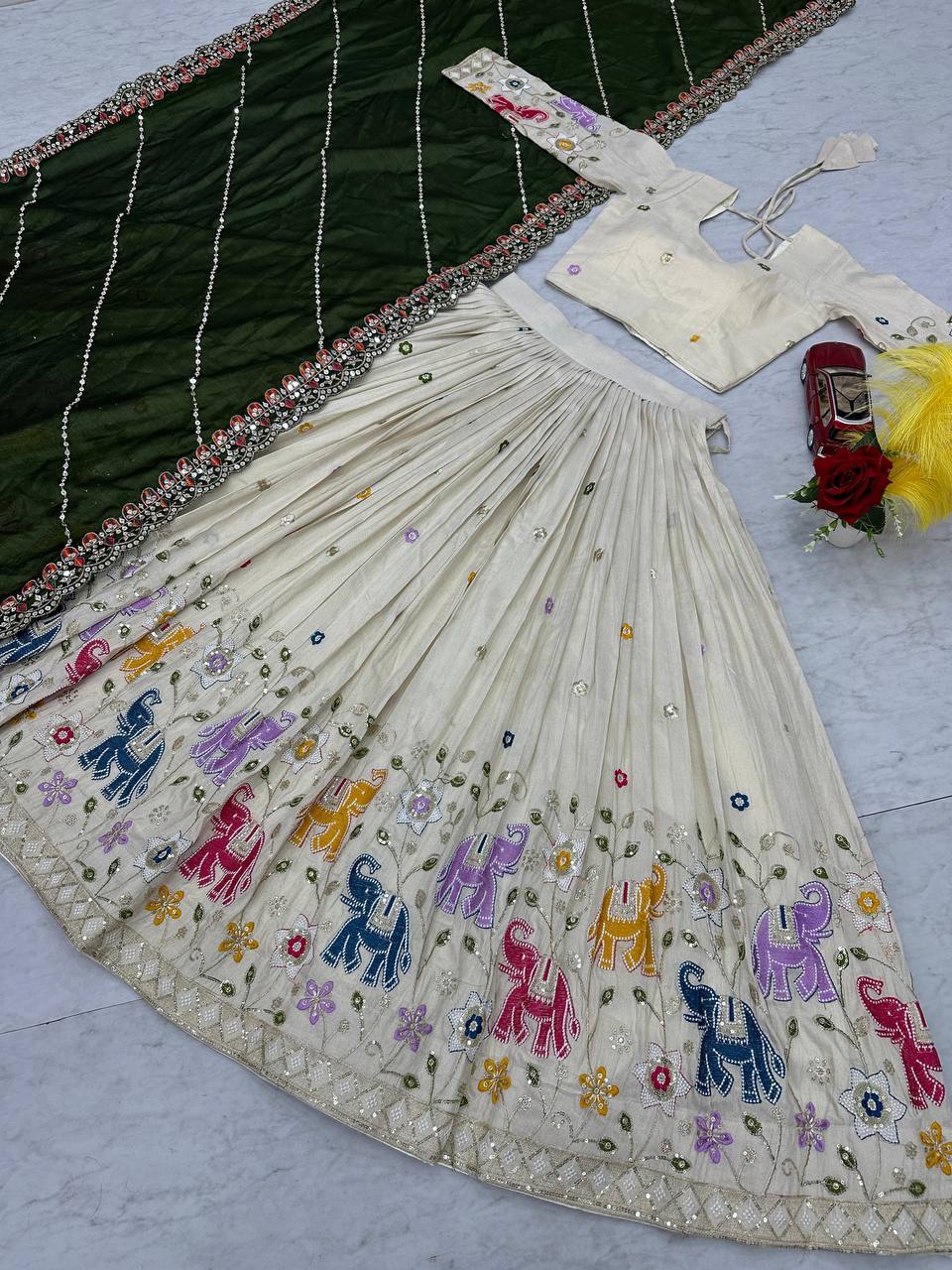 Close-up of the off-white lehenga choli and olive green dupatta, detailing embroidery.