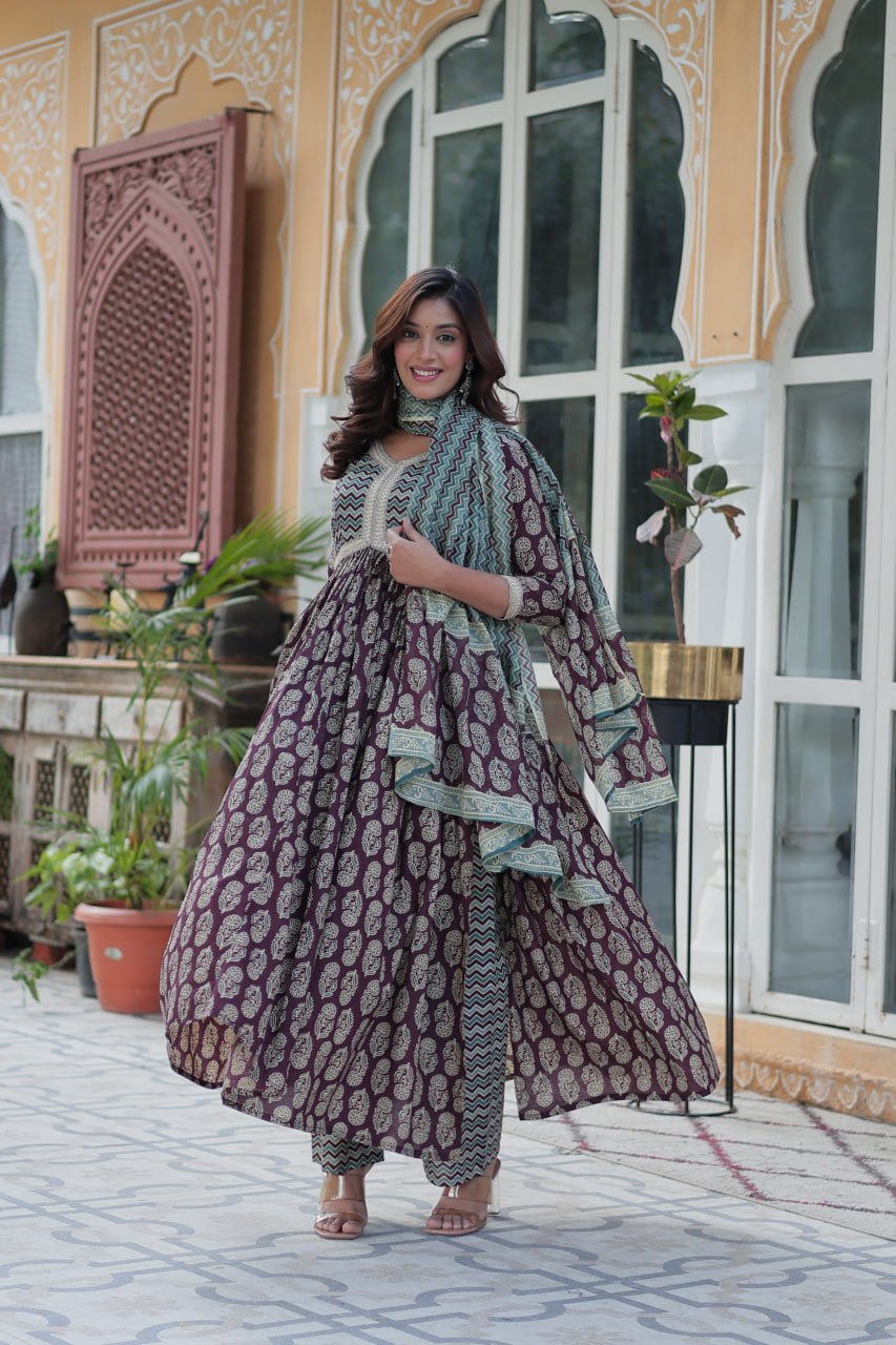 Elegant maroon and gold cotton kurti set, teal chevron dupatta, flared Anarkali style, outdoor setting.