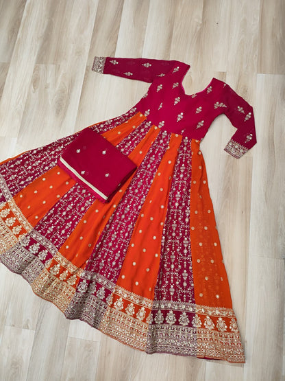 Flat lay of a pink and orange designer gown with dupatta, showcasing embroidery.