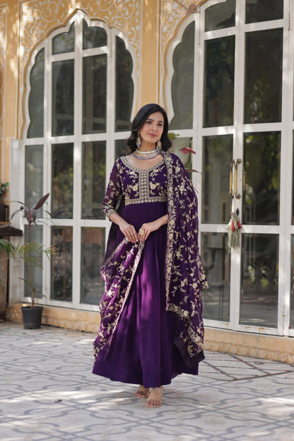 Model twirling in purple embroidered Indian gown with dupatta.