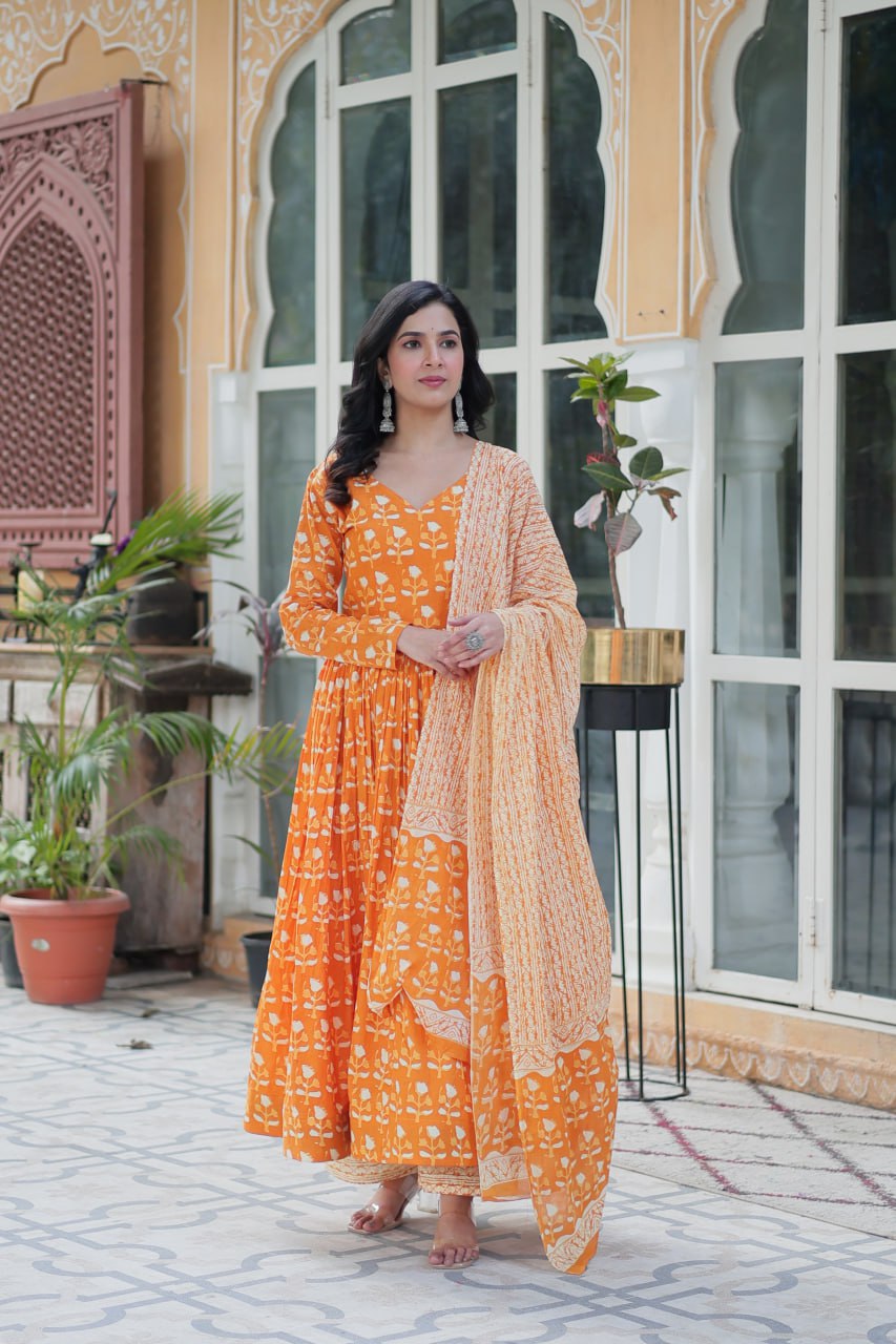 Woman in a vibrant orange pure cotton kurti set with V-neck and matching dupatta, perfect for summer.