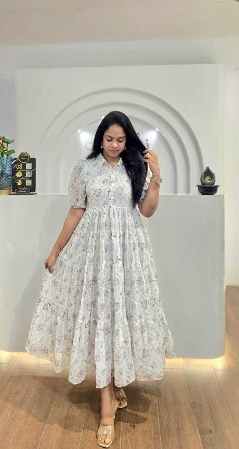 Woman wearing a lavender floral maxi dress with button front, smiling.