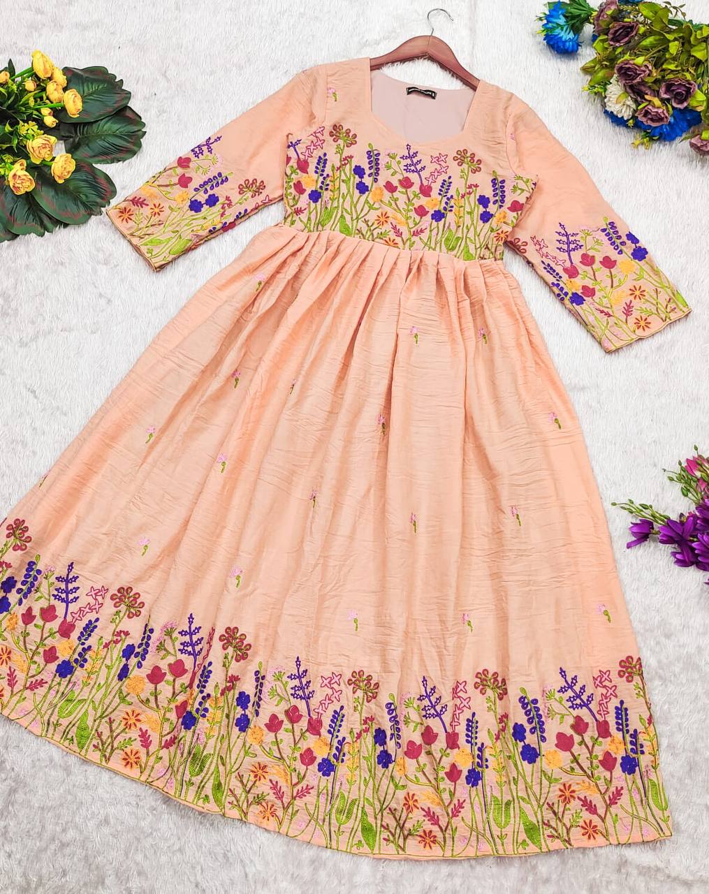 Peach Maska Cotton Dress on a white surface, highlighting the floral embroidered hem and sleeves.
