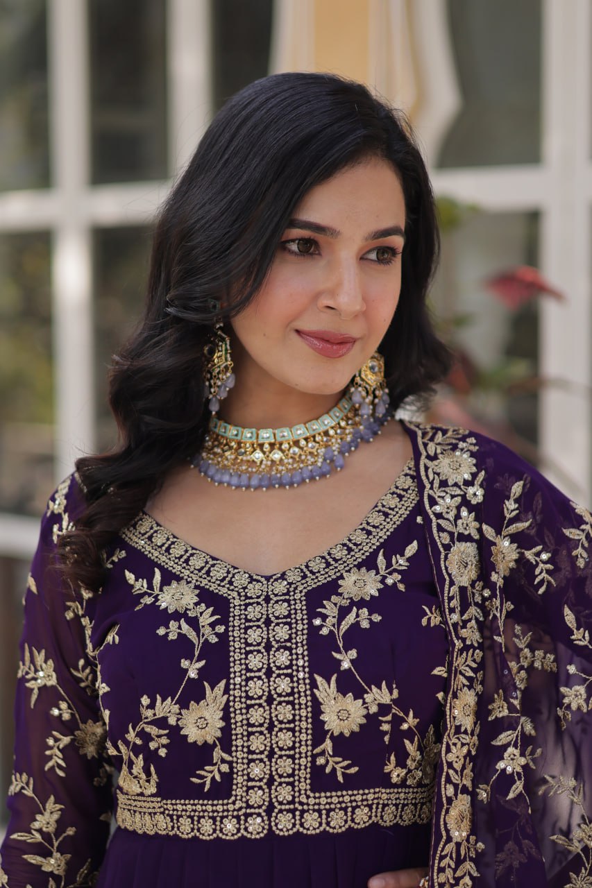 Close-up of intricate gold floral embroidery on the purple gown.